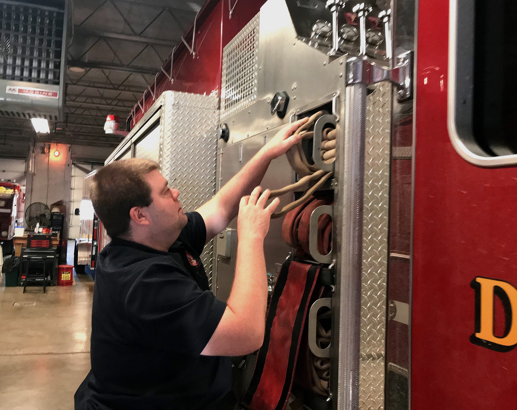 Tri-Township Fire Station firefighter Miles Bilikam does a routine check on a pumper truck Jan. 21 at the station, 495 Sunbury Road.  The fire station will move less than a mile east to a site off Bowtown Road.